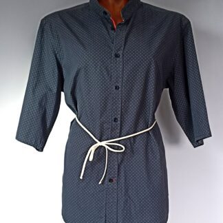 Chemise cintrée à la taille, bleu foncé avec petit motif blanc. Manches trois quart. Photo sur mannequin. La chemise est présentée de face, fermée. Le lien qui cintre la taille est noué devant.