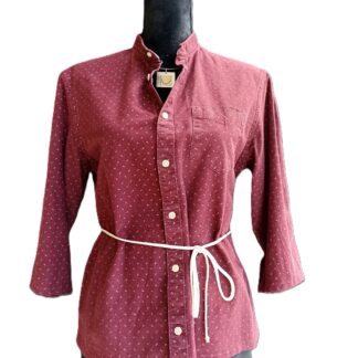 Chemise cintrée à la taille, bordeaux avec petit motif blanc. Manches trois quart. Photo sur mannequin. La chemise est présentée de face, fermée. Le lien qui cintre la taille est noué devant.