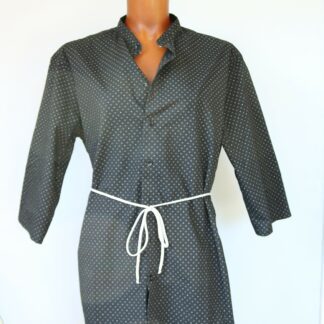 Chemise cintrée par lien, noire avec petits motifs blanc. Col mao. Manches trois quart. Glissière pour lien au dos et lien blanc cassé noué devant. Sur mannequin. Vue face.